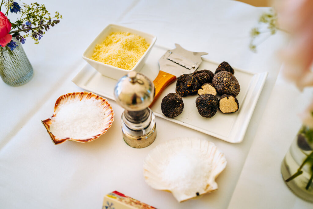 Parmesan, truffle, and salt displayed elegantly in white plates and clam shells for a wedding catering event.