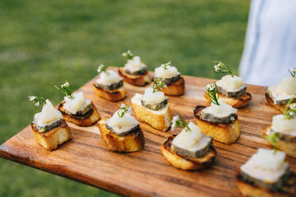 a board of canapés with wild flowers and fresh produce