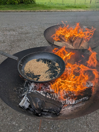 spices toasting in a cast-iron pan on open fire pits